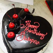 Heart shaped Chocolate cake garnished with cherries